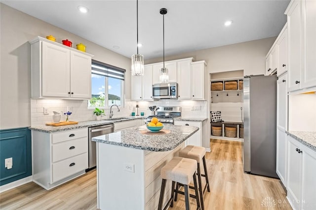 1239 Champion Way, Washington Twp, OH 45458 - kitchen with appliances with stainless steel finishes, light wood-style floors, a kitchen bar, backsplash, and recessed lighting