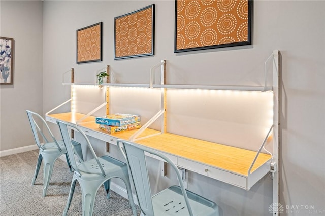 carpeted dining room featuring baseboards