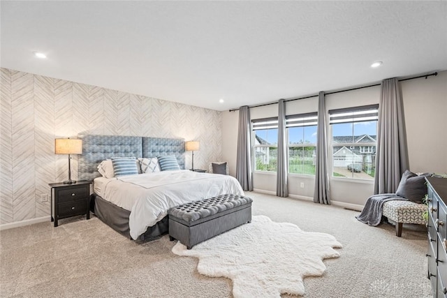 carpeted bedroom featuring wallpapered walls, an accent wall, baseboards, and recessed lighting