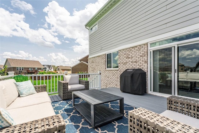 wooden deck with outdoor lounge area, a grill, and a residential view
