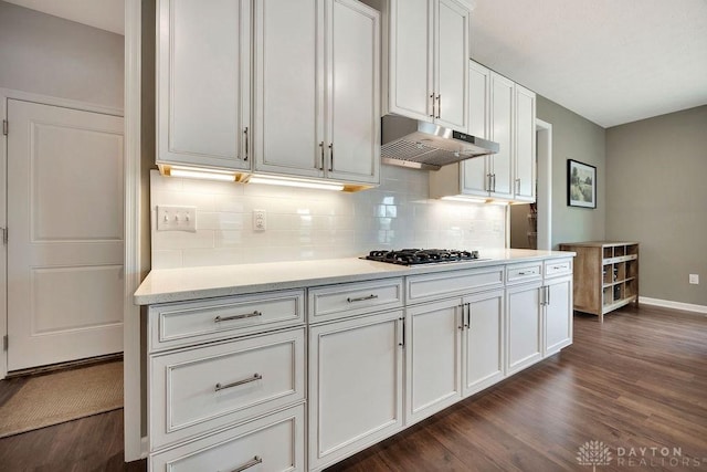 3732 Oak Creek Dr, Sugarcreek Township, OH 45440 - kitchen with under cabinet range hood, dark wood finished floors, gas stovetop, and tasteful backsplash