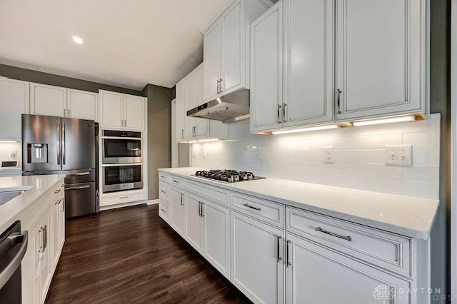 3732 Oak Creek Dr, Sugarcreek Township, OH 45440 - kitchen with stainless steel appliances, under cabinet range hood, backsplash, dark wood-type flooring, and white cabinetry
