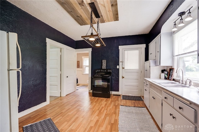 1000 Haviland Ave, Dayton, OH 45410 - kitchen with freestanding refrigerator, a sink, black range with electric stovetop, light countertops, and light wood-style flooring