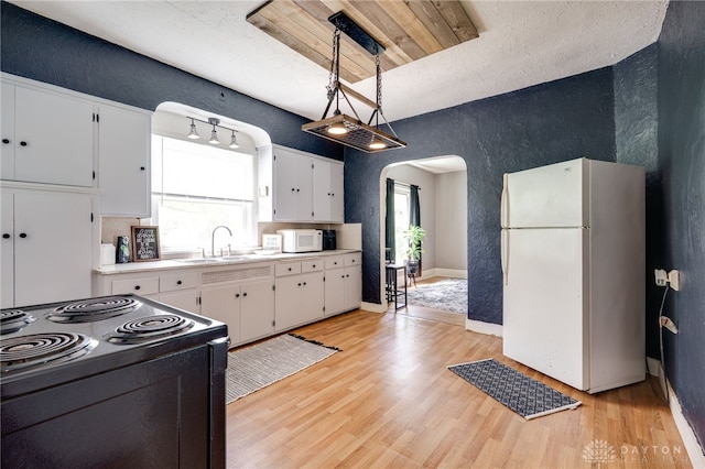 1000 Haviland Ave, Dayton, OH 45410 - kitchen featuring white appliances, arched walkways, a textured wall, white cabinets, and light wood-style floors