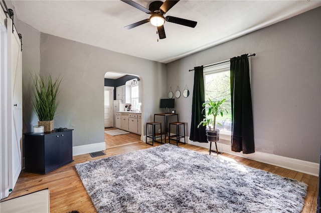 1000 Haviland Ave, Dayton, OH 45410 - living area with arched walkways, a ceiling fan, light wood-type flooring, baseboards, and a barn door