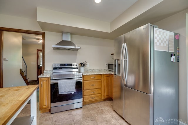200 S Village, Washington Twp, OH 45459 - kitchen featuring stainless steel appliances, wall chimney range hood, butcher block counters, light tile patterned floors, and brown cabinets
