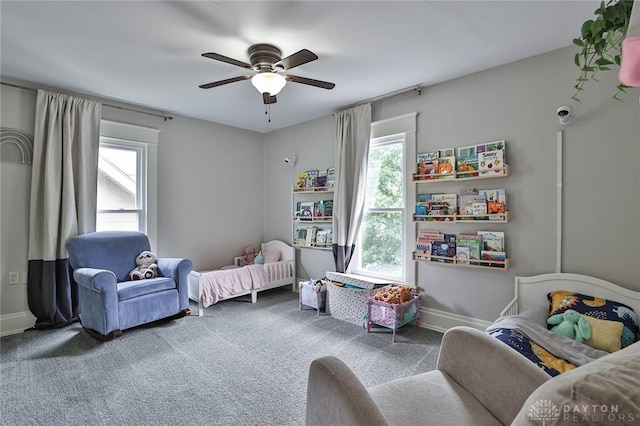 carpeted bedroom featuring multiple windows, a ceiling fan, and baseboards