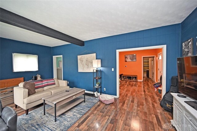 living room with wood finished floors, beamed ceiling, and baseboards