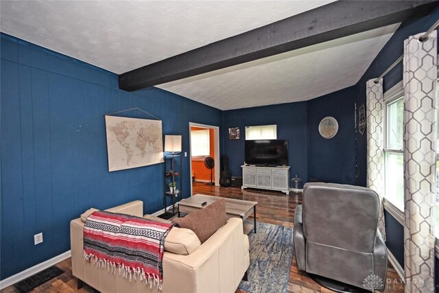 living room featuring wood finished floors, beamed ceiling, and baseboards