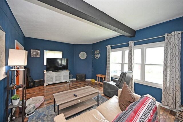 living room with wood finished floors, beamed ceiling, and baseboards