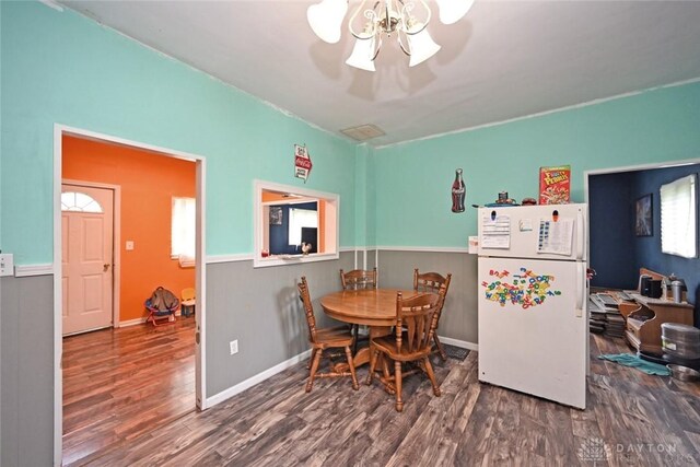 dining area featuring wood finished floors and a wainscoted wall