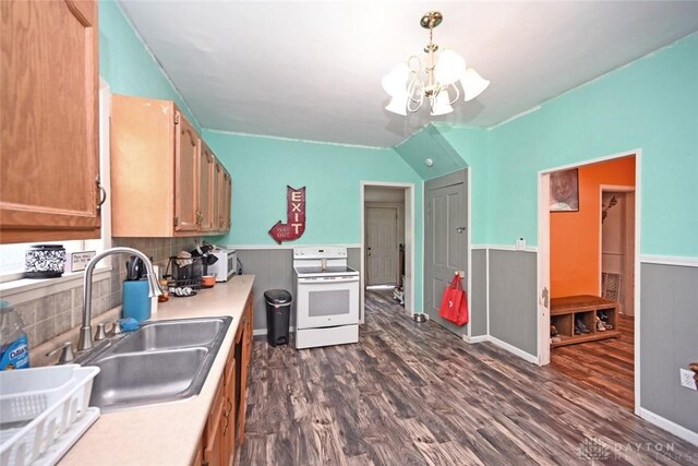 kitchen with electric stove, a sink, a chandelier, dark wood-type flooring, and wainscoting