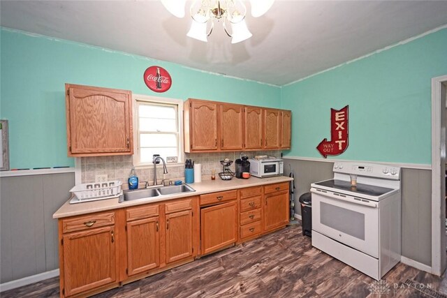 kitchen featuring white appliances, a sink, dark wood-style flooring, a wainscoted wall, and light countertops