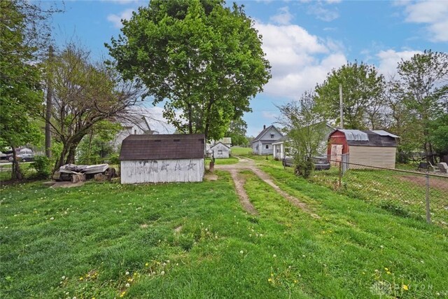 view of yard featuring a shed, an outbuilding, and dirt driveway