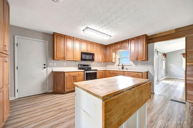 2774 N Law Rd, Oxford, OH 45056 - kitchen featuring black microwave, stainless steel electric stove, light wood finished floors, a sink, and butcher block counters