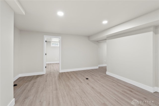 below grade area with light wood-style flooring, baseboards, and recessed lighting