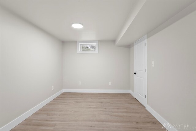 below grade area with light wood-style floors and baseboards