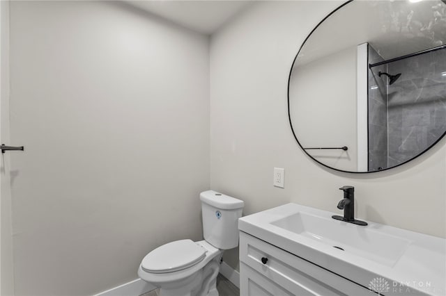 bathroom with toilet, baseboards, and vanity