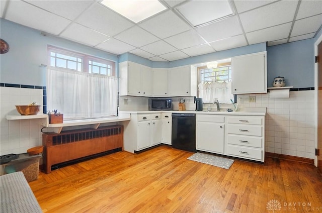 4207 Morningside Blvd, Dayton, OH 45432 - kitchen featuring black dishwasher, radiator heating unit, stainless steel microwave, light wood-style flooring, and a sink