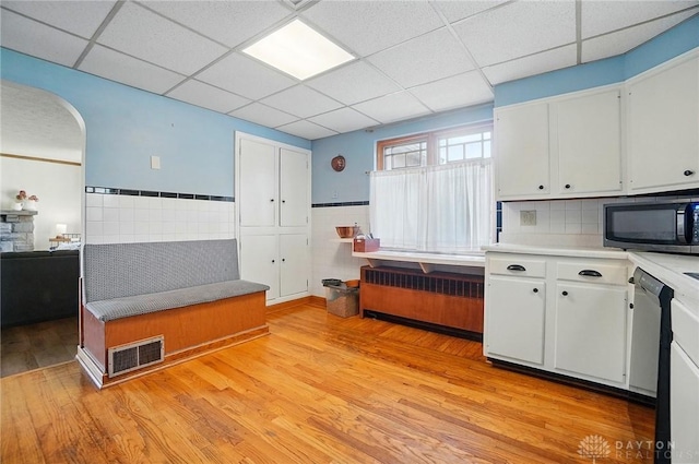 4207 Morningside Blvd, Dayton, OH 45432 - kitchen with black microwave, light wood-style floors, white cabinets, a drop ceiling, and light countertops
