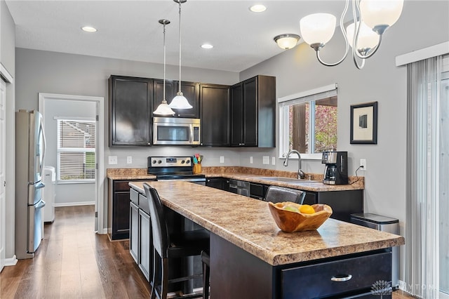 40 Shady Pines Ave, Springboro, OH 45066 - kitchen with appliances with stainless steel finishes, a sink, a kitchen island, dark wood-style floors, and light countertops