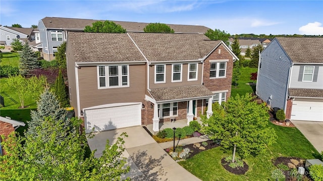 40 Shady Pines Ave, Springboro, OH 45066 - view of front of house featuring an attached garage, concrete driveway, brick siding, a shingled roof, and a residential view