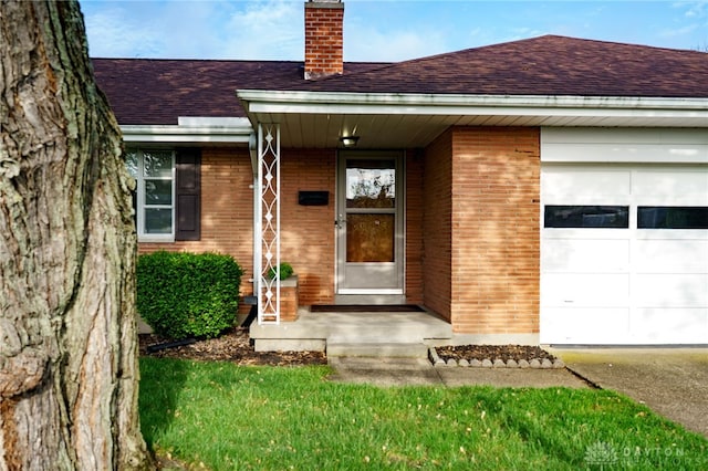 4231 Maricarr Dr, Dayton, OH 45429 - property entrance featuring a chimney, a shingled roof, a garage, brick siding, and concrete driveway