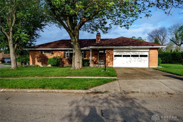 4231 Maricarr Dr, Dayton, OH 45429 - ranch-style home featuring a chimney, a front lawn, a garage, driveway, and brick siding