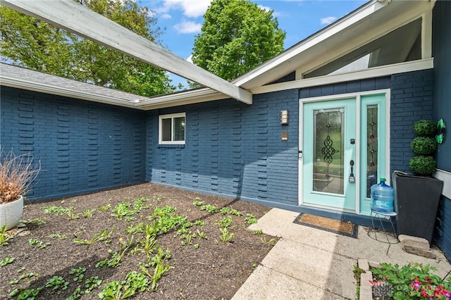view of exterior entry featuring brick siding