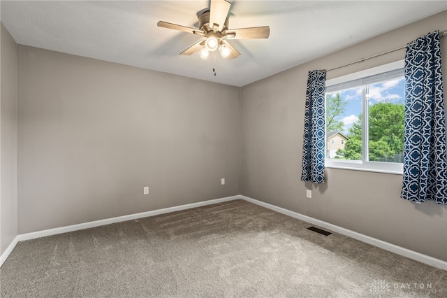 carpeted empty room with baseboards and a ceiling fan