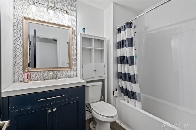 full bath with toilet, shower / bath combo with shower curtain, and vanity