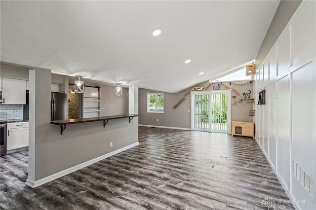 unfurnished living room featuring dark wood-style floors, recessed lighting, baseboards, and lofted ceiling