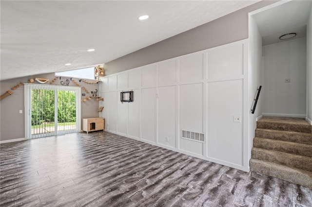 unfurnished living room with wood finished floors, recessed lighting, stairway, lofted ceiling, and baseboards