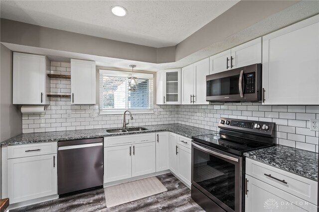 kitchen featuring stainless steel appliances, a sink, open shelves, white cabinetry, and dark wood-style floors