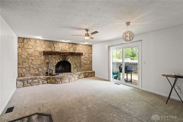 unfurnished living room with baseboards, a fireplace, carpet flooring, a ceiling fan, and a textured ceiling