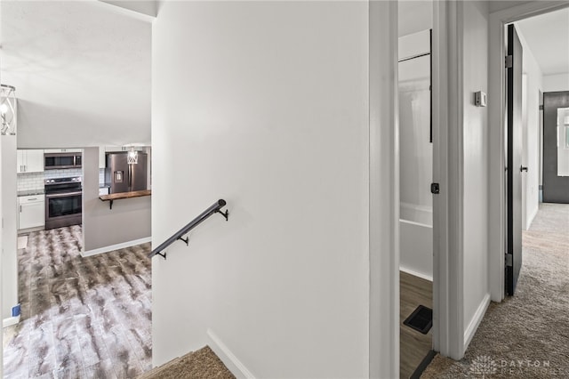 stairway with baseboards and wood finished floors