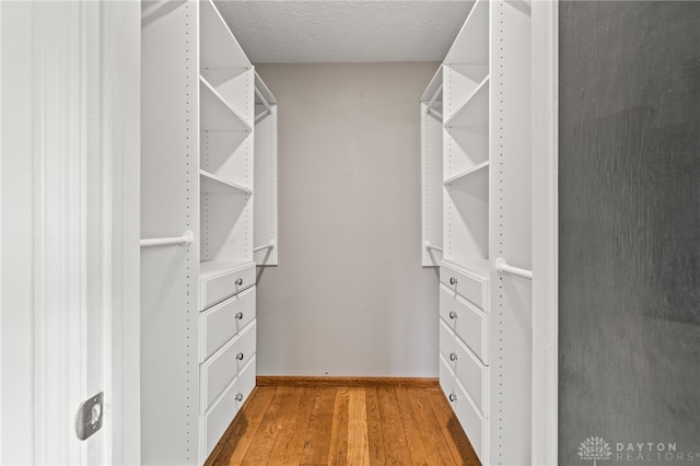 walk in closet with wood finished floors