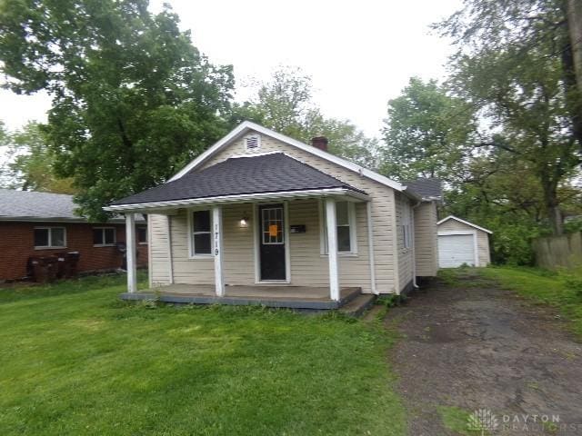 1719 Lamberton St, Middletown, OH 45044 - bungalow featuring covered porch, asphalt driveway, a front lawn, an outbuilding, and a detached garage