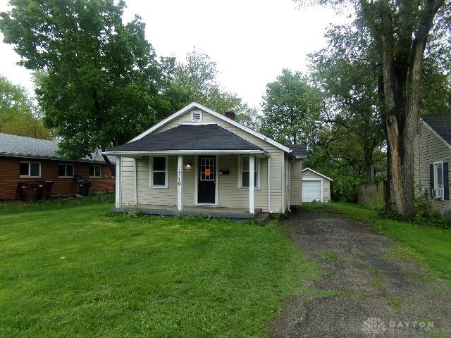 1719 Lamberton St, Middletown, OH 45044 - bungalow-style home featuring covered porch, an outbuilding, a front yard, a detached garage, and driveway
