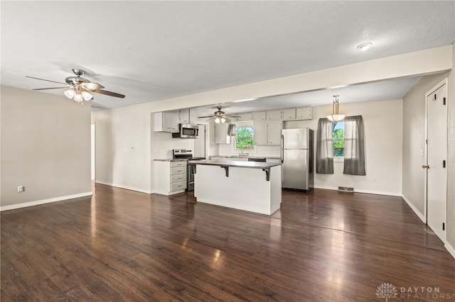 unfurnished living room featuring a ceiling fan, dark wood finished floors, and baseboards