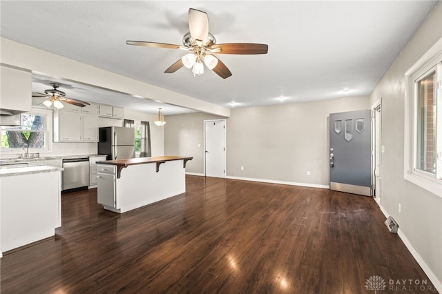 kitchen with stainless steel appliances, ceiling fan, a kitchen breakfast bar, and healthy amount of natural light