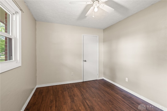 unfurnished room with dark wood-style flooring, baseboards, a ceiling fan, and a textured ceiling
