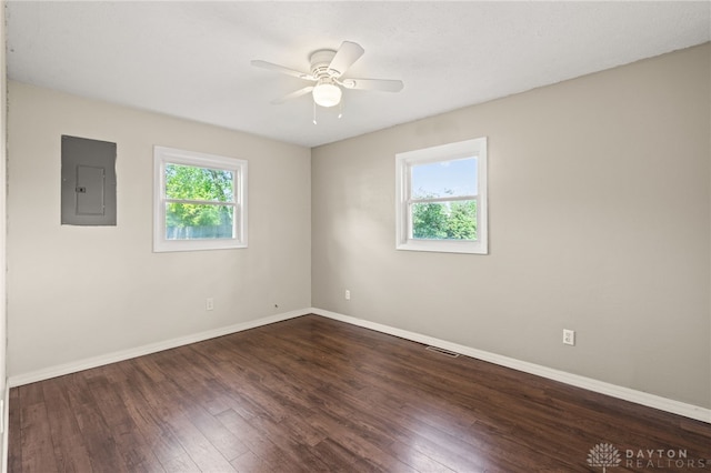 spare room with electric panel, ceiling fan, hardwood / wood-style floors, and baseboards
