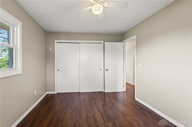 unfurnished bedroom featuring wood finished floors, baseboards, a closet, and ceiling fan