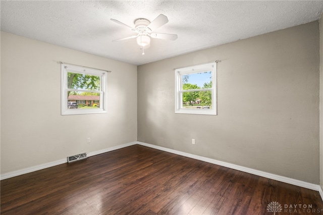 unfurnished room with wood-type flooring, plenty of natural light, ceiling fan, baseboards, and a textured ceiling