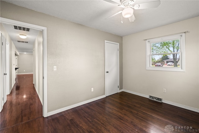 unfurnished room featuring wood finished floors, a ceiling fan, and baseboards