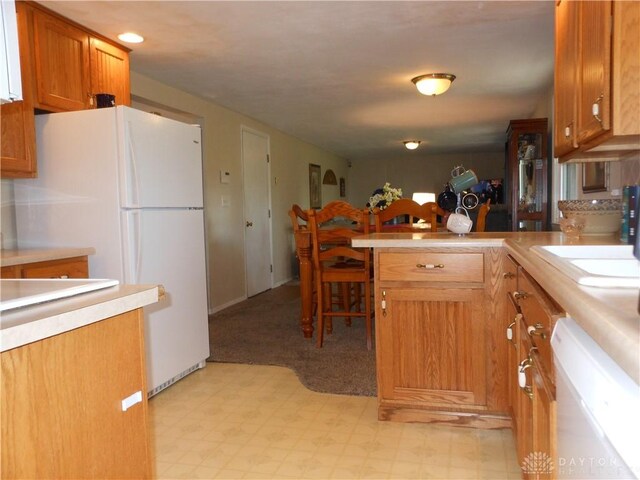 8189 Oakes Rd, Arcanum, OH 45304 - kitchen featuring white appliances, light flooring, brown cabinetry, light countertops, and a peninsula