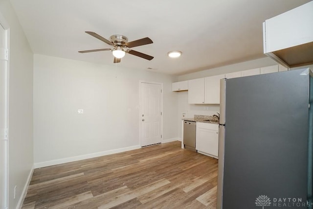 9738 Gibralter Dr, Colerain Township, OH 45251 - kitchen with appliances with stainless steel finishes, light wood-type flooring, white cabinetry, a ceiling fan, and baseboards