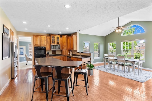9378 Oak Brook Dr, Clearcreek Twp, OH 45458 - kitchen with appliances with stainless steel finishes, baseboards, a breakfast bar area, a textured ceiling, and recessed lighting