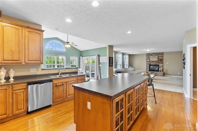9378 Oak Brook Dr, Clearcreek Twp, OH 45458 - kitchen with stainless steel dishwasher, a sink, a ceiling fan, light wood-style floors, and dark countertops